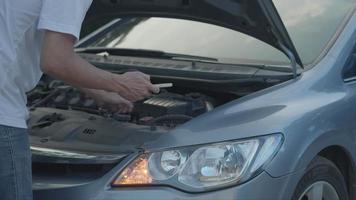 uomo uso mobile Telefono dai un'occhiata assicurazione dovuto per incidente auto attraverso un' mobile applicazione system.man ricerche per un' box auto per avere il suo auto riparato durante un' rurale tour. auto assicurazione concetto. video