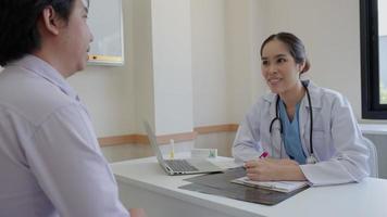 una doctora asiática entrevista y registra la salud del paciente para el tratamiento del programa establecido. el médico de consulta del paciente recibe atención médica después de la rehabilitación. video