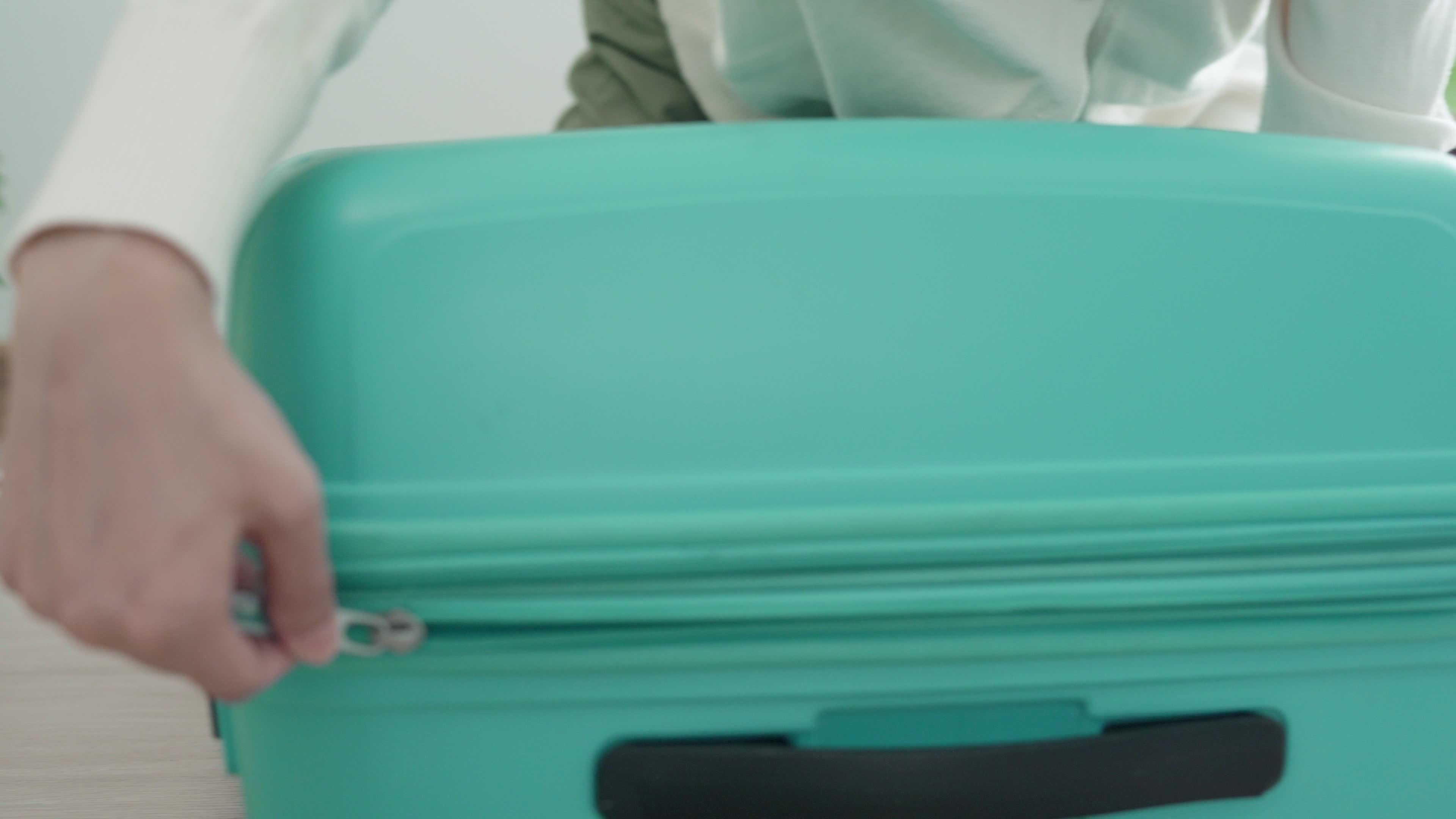 A woman opening a suitcase for put clothes and go to travel. A woman is preparing her bag for a