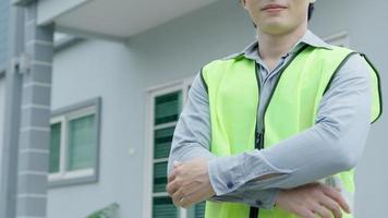 inspector, ingeniero, capataz o contratista se cruza orgulloso de brazos para inspeccionar la calidad de su trabajo. los arquitectos trabajan para construir la casa antes de entregársela al propietario. desarrollar nueva finca. video