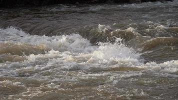 el río sucio fluye rápido después de fuertes lluvias video