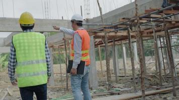 ingenieurs team controleren de vooruitgang en bouw Aan plaats. aannemer en inspecteur inspectie bouw gedurende project.civiel voor mannen controleren kwaliteit zekerheid. controle, inspecteren, kwaliteit controle. video