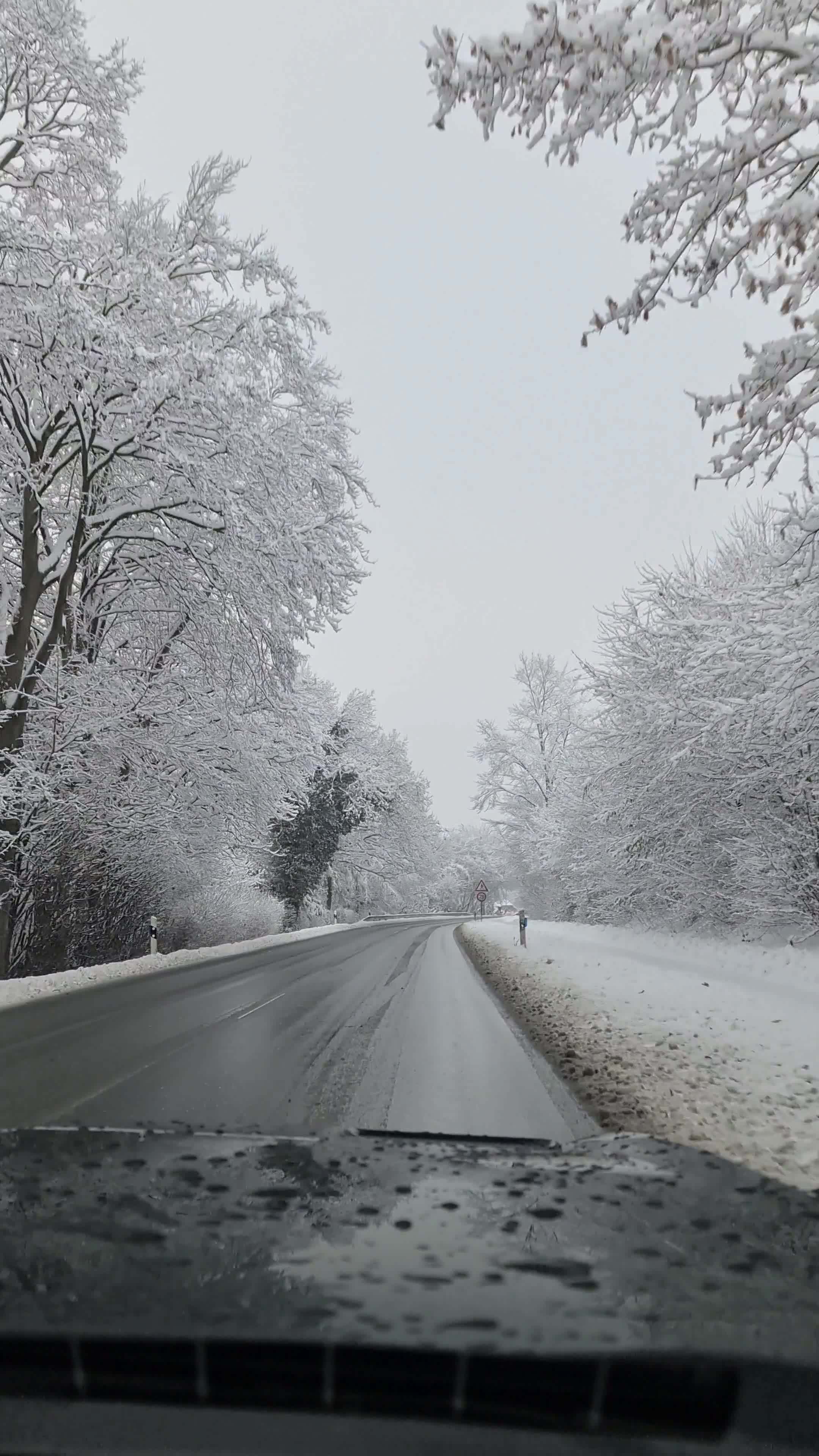 View From The Windscreen Of A Car Driving On A Snowy Road With Many