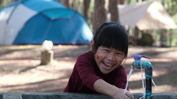 schattig Aziatisch weinig meisje het wassen haar handen in de park. weinig meisje het wassen haar handen onder de kraan na aan het doen een kleur werkzaamheid in de buurt de tent. schoon en hygiëne concept. video