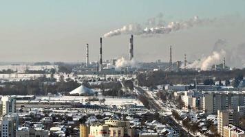 aerial view on smoked pipes of chemical enterprise plant with snow. Air pollution concept. Winter industrial landscape environmental pollution waste of thermal power plant