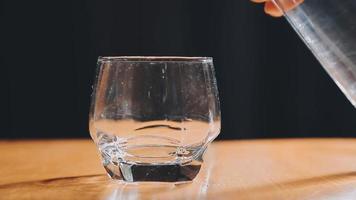 Wasser trinken. Die Hand der Frau gießt frisches, reines Wasser aus dem Krug in ein Glas. Gesundheits- und Ernährungskonzept. gesunder Lebensstil. Gesundheit und Schönheit. Hydratation. video