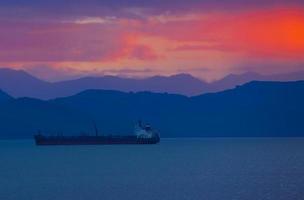 barco de transporte al atardecer en la bahía de avacha en la península de kamchatka foto