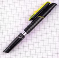 black pen for writing on white checkered notebook paper photo