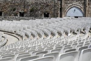 empty auditorium with gray plastic chairs in an ancient amphitheater photo