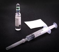 Medical syringe and glass vial on a black background. photo