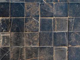 textura de suelo de baldosas cuadradas negras ásperas y agrietadas abstractas foto