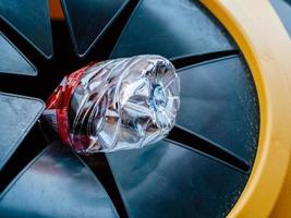 Plastic bottle goes into a yellow stationary rubbish bin. Right way of rubbish sorting photo