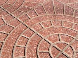 Diagonal view on a rounded pattern on a red stone pavement photo