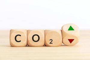 CO2 emissions up or down concept. Symbol on wooden blocks and turning dice with up and down arrows. Copy space photo