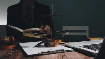 Business and lawyers discussing contract papers with brass scale on desk in office. Law, legal services, advice, justice and law concept picture with film grain effect video