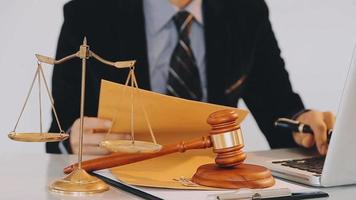 Business and lawyers discussing contract papers with brass scale on desk in office. Law, legal services, advice, justice and law concept picture with film grain effect video