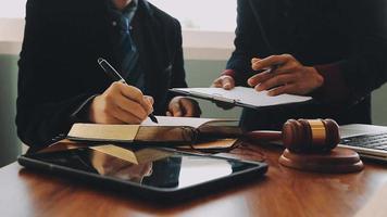 zaken en advocaten bespreken contractpapieren met koperen schaal op bureau in kantoor. wet, juridische diensten, advies, rechtvaardigheid en wet concept foto met film grain effect video