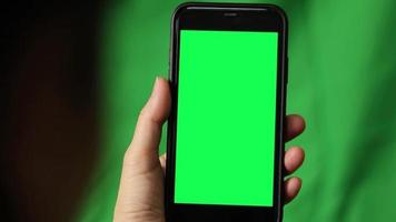 Green screen, smartphone green screen in hand, hand holding smart phone video