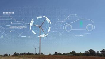 coche de vehículo eléctrico en el holograma en una turbina eólica con holograma de signo de ecología ambiental energía limpia sostenible. video