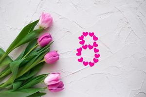 hermosos tulipanes de primavera y corazones en forma de ocho sobre fondo de piedra gris. concepto de día de san valentín, día de la mujer ocho de marzo, día de la madre. foto