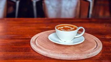 A cup of coffee on wooden table in coffee shop photo