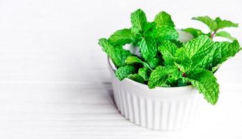 Mint leaf or Fresh mint herbs in a white bowl on white background