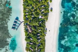 Aerial view on Maldives island. Beautiful sea and coral reef with luxury water villas. Tropical resort, amazing exotic landscape. Summer vacation beach and holiday scenery. Tourism destination