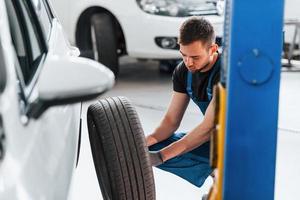 Auto mechanic working in garage. Repair service photo