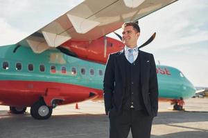 Steward. Crew of airport and plane workers in formal clothes standing outdoors together photo