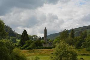 Stone round tower and some ruins of a monastic settlement originally built in the 6th century photo