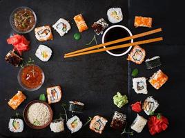 Traditional Japanese food - sushi, rolls and sauce on a dark background. Top view photo