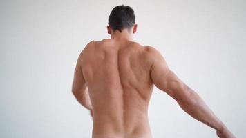 Athletic Muscular Man in Underwear Kneads His Back and Spine. Guy is Suffering from Back Pain. Human Anatomy and Healthy Body Concept. Slow Motion. Vertical Video. video