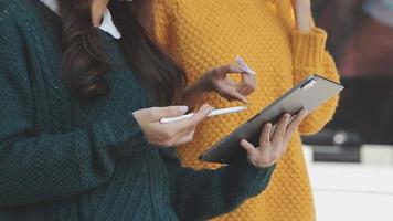 volwassen zakenman gebruik makend van een digitaal tablet naar bespreken informatie met een jonger collega in een modern bedrijf lounge video