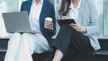 Mature businessman using a digital tablet to discuss information with a younger colleague in a modern business lounge video