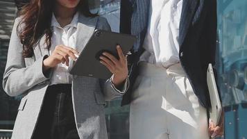 Mature businessman using a digital tablet to discuss information with a younger colleague in a modern business lounge video