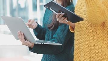 volwassen zakenman gebruik makend van een digitaal tablet naar bespreken informatie met een jonger collega in een modern bedrijf lounge video