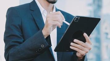 Mature businessman using a digital tablet to discuss information with a younger colleague in a modern business lounge video