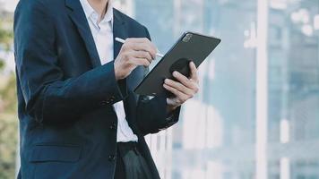 Mature businessman using a digital tablet to discuss information with a younger colleague in a modern business lounge video