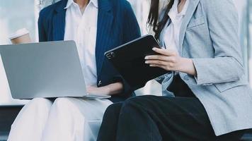 Reifer Geschäftsmann, der ein digitales Tablet verwendet, um Informationen mit einem jüngeren Kollegen in einer modernen Business-Lounge zu besprechen video