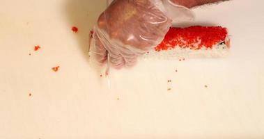 topp se av en sushi rulla varelse skära in i bitar med en skarp kniv - över huvudet skott, långsam rörelse video