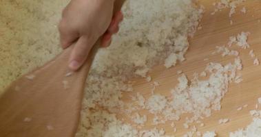 Chef Mixing Japanese White Rice Using Wooden Spoon For Sushi Dish In The Kitchen. - high angle shot video