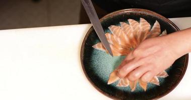 regelen van plakjes van vers rauw Zalm voor sashimi portie in een bord in een sushi restaurant - hoog hoek schot, langzaam beweging video