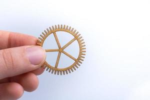 Gear wheel in hand on white background as concept of engineering photo