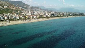 praia de kleopatra em alanya, turquia. drone view linha costeira long beach. verão, sol, palmeiras, areia, mar e castelo de alanya. video