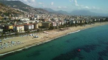 praia de kleopatra em alanya, turquia. drone view linha costeira long beach. verão, sol, palmeiras, areia, mar e castelo de alanya. video