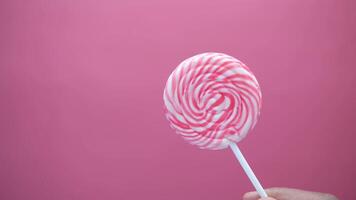 Close Up Of Rainbow Heart Shape Lollipop On Red Background video