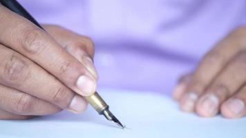 mans mano escribiendo con bolígrafo sobre papel