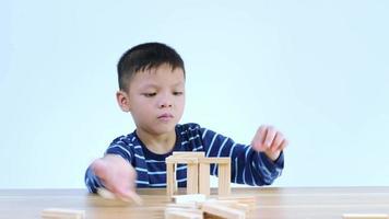 asiatischer junge, der mit einem holzpuzzle spielt video