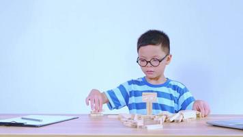 niño asiático jugando con un rompecabezas de madera video