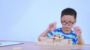 Asian boy playing with a wooden puzzle video